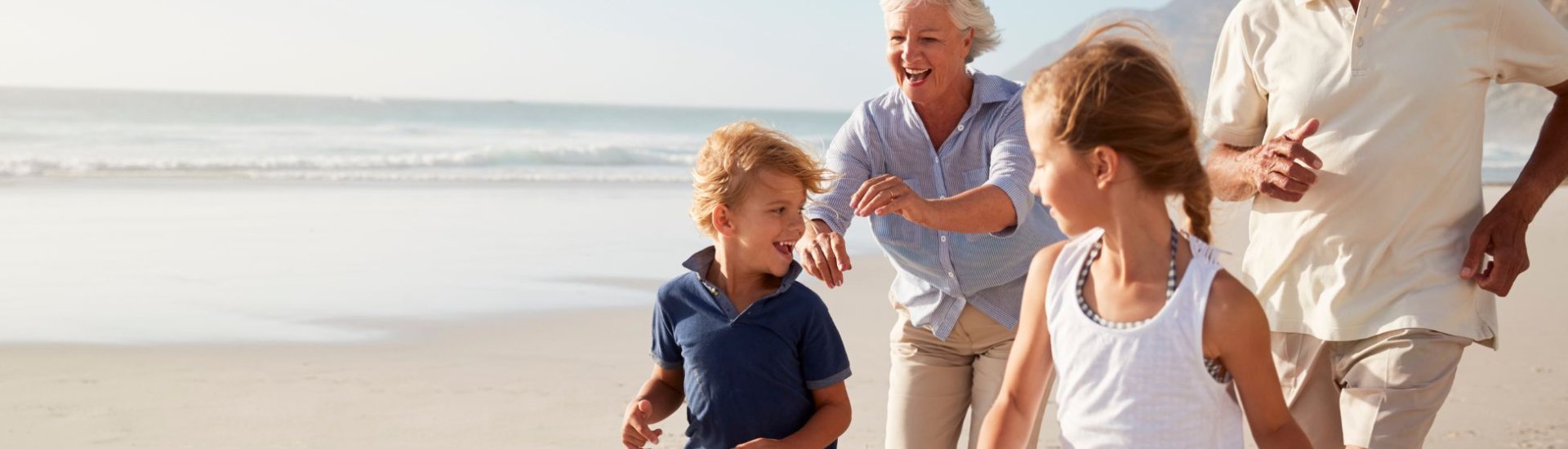 Grandchildren and Grandparents running on beach