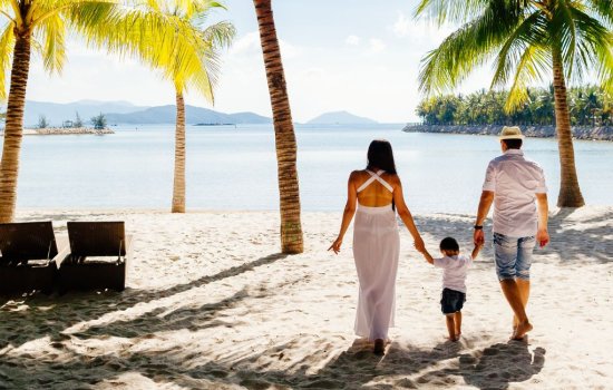 married couple with toddler on a beach